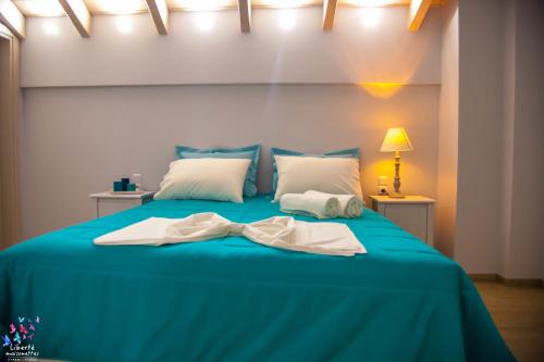 a blue bed with a bow tie on it at Liberte Maisonettes in Parga