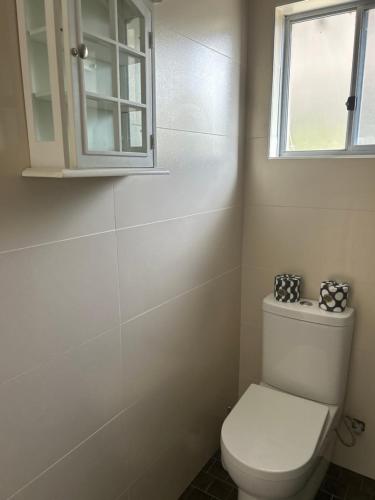 a bathroom with a white toilet and a window at Koombana Retreat in Perth