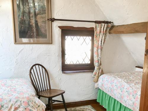 1 dormitorio con 1 cama, 1 silla y 1 ventana en Little Whitnell Cottage, en Nether Stowey