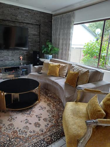 ein Wohnzimmer mit einem Sofa und einem TV in der Unterkunft Margate Accomodation in Margate