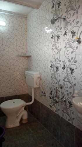 a bathroom with a toilet and a sink at Coconut Village Resort in Alībāg