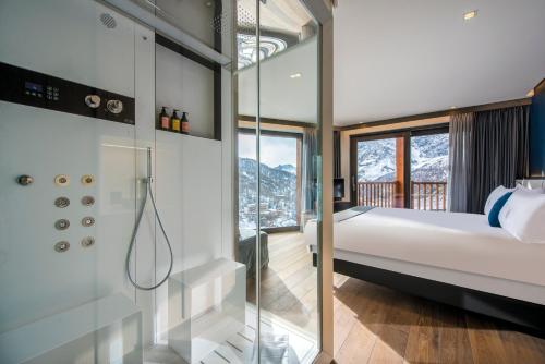 1 dormitorio con 1 cama y ducha acristalada en Hotel Principe delle Nevi, en Breuil-Cervinia