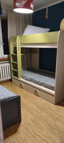 two bunk beds in a room with a wooden floor at Sosnowiec przy placu in Sosnowiec