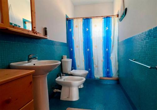 Baño azul con lavabo y aseo en Appartamento BICA. Stella Maris Exclusive en Calheta Do Maio