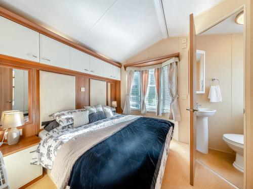 una camera con un grande letto e servizi igienici di Hafod Caravan - Uk45717 a Brynteg