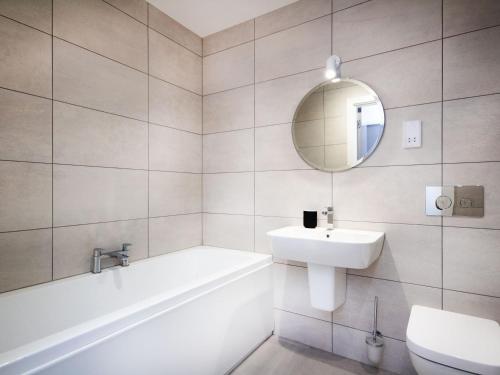 a bathroom with a tub sink and a mirror at Caledonia View in Aviemore