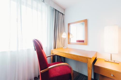 a room with a desk and a chair and a mirror at JR Kyushu Station Hotel Kokura in Kitakyushu