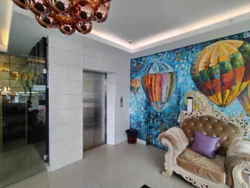 um quarto com um sofá e uma pintura de balões de ar quente em Smile Hotel Shah Alam Seksyen 9 em Shah Alam