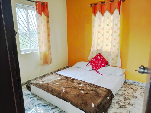 een klein bed in een kamer met een raam bij Mannat Inn Homestay (Mysore) in Mysore