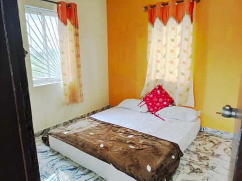 a small bed in a room with a window at Mannat Inn Homestay (Mysore) in Mysore
