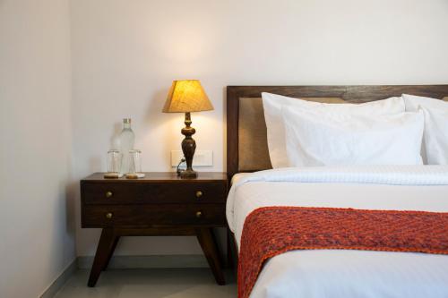 a bedroom with two beds and a lamp on a night stand at Naila Kothi - A Luxury Boutique Royal Suites in Jaipur in Jaipur