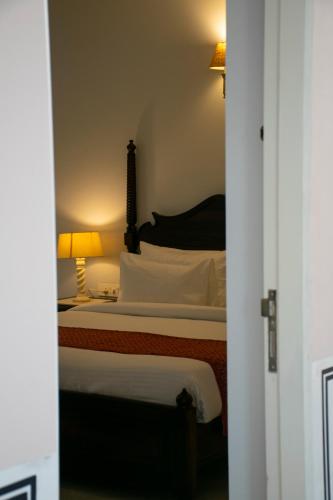a bedroom with a large bed with a lamp on it at Naila Kothi - A Luxury Boutique Royal Suites in Jaipur in Jaipur