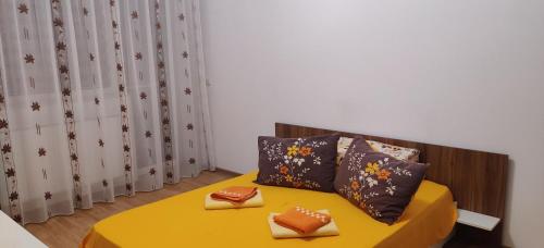 巴克烏的住宿－3 camere, zona linistita, parcare privata，一间卧室配有黄色的床和两个枕头