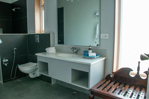 a bathroom with a sink and a toilet and a mirror at Naila Kothi - A Luxury Boutique Royal Suites in Jaipur in Jaipur