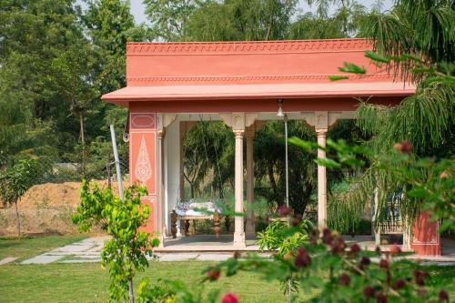 Naila Kothi, Jaipur في جايبور: شرفة مع سقف احمر في حديقة