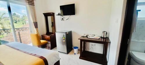 a hotel room with a bed and a television on the wall at Ivory Laze Hotel in Negombo