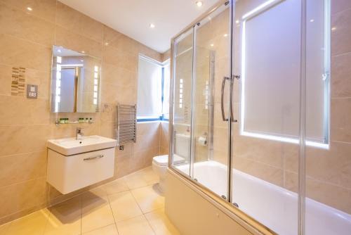 uma casa de banho com um chuveiro, um WC e um lavatório. em The Shoreditch Inn em Londres