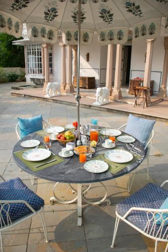 a table with plates of food on a patio at Naila Kothi - A Luxury Boutique Royal Suites in Jaipur in Jaipur