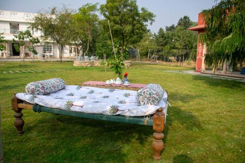 a bed in a field with pillows on it at Naila Kothi - A Luxury Boutique Royal Suites in Jaipur in Jaipur