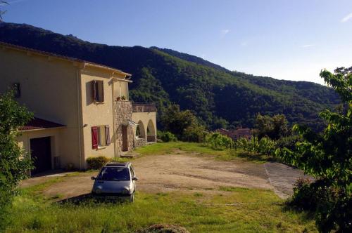 um carro estacionado ao lado de um edifício num campo em A 2 minutes rivière 25 minutes Ajaccio plages linge et PARKING inclus em Ucciani