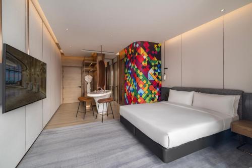 a bedroom with a white bed and a table at Maqo Changsha in Changsha