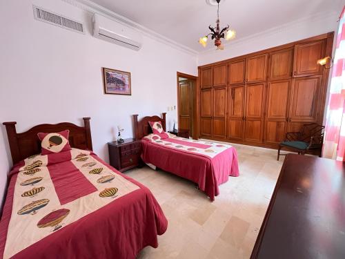 Un dormitorio con dos camas y una mesa dentro. en Metro Golf Villa, en Paraíso