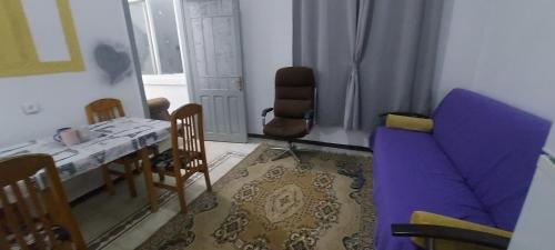 sala de estar con mesa y sofá púrpura en Израиль Хайфа Адар, en Haifa