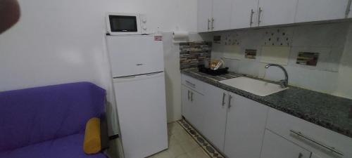 una pequeña cocina con nevera blanca y fregadero en Израиль Хайфа Адар, en Haifa