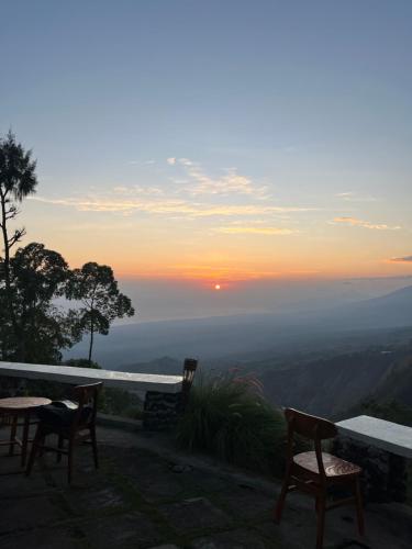 a view of the sunset from a table and chairs at Bali Sunrise Camp & Glamping in Kintamani