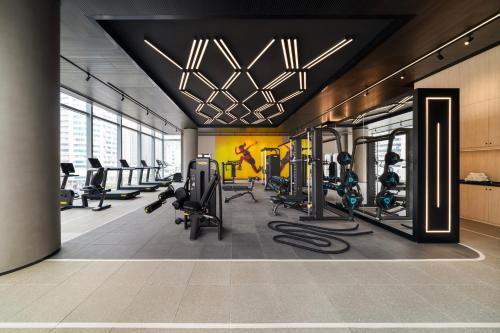 a gym with treadmills and machines in a room at Maqo Changsha in Changsha