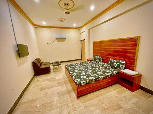 ein Schlafzimmer mit einem Bett und einem Stuhl darin in der Unterkunft Hotel Inn Gulistan-e-Jhour in Karatschi