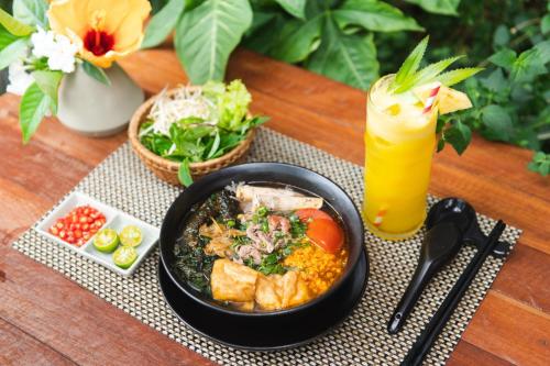 una mesa con un tazón de comida y una bebida en Luxury Homestay Vinhomes Dragonbay Hạ Long, en Ha Long