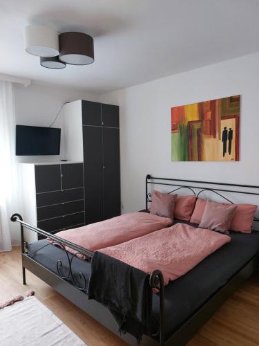 - une chambre avec un lit doté de draps rouges et d'oreillers roses dans l'établissement Haus Muigg, à Innsbruck