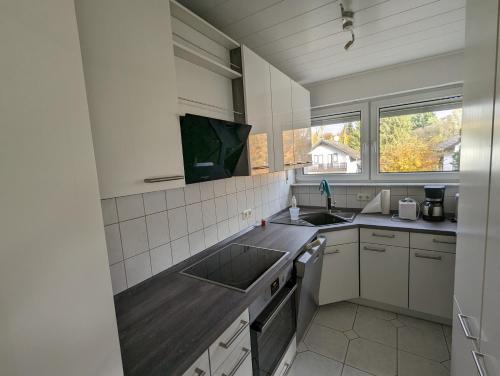 una pequeña cocina con fregadero y ventana en Ruhige, moderne Wohnung bei Darmstadt in Roßdorf en Roßdorf