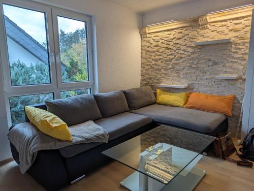 sala de estar con sofá y mesa de cristal en Ruhige, moderne Wohnung bei Darmstadt in Roßdorf, en Roßdorf