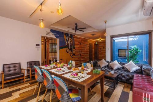 a living room with a table and a couch at Cyclo Villa - JUNGLIA15分! 美ら海25分! ビーチ古宇利島すぐ! BBQ無料貸出! in Nago