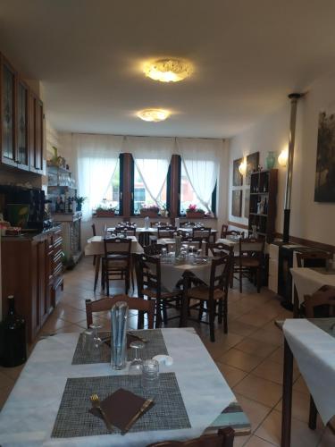 a dining room with tables and chairs and windows at Da Teresa in Bardineto