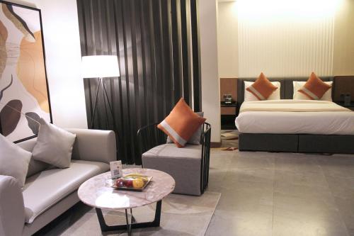 a hotel room with a bed and a couch and a table at Al Muhaidb Residence Jawazat in Riyadh