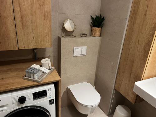 een kleine badkamer met een toilet en een wasmachine bij Marsonia apartments in Zagreb