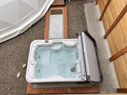 a hot tub sitting on the floor next to a door at Glamping Dome - Pinot in Cromwell