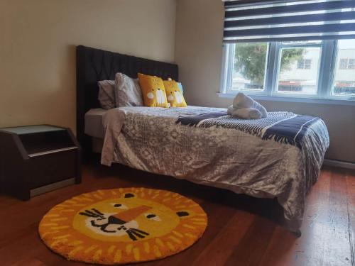 a bedroom with a bed and a rug on the floor at Mt Eden Master Suite RM1 in Auckland