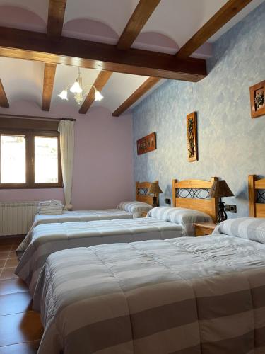 eine Reihe von Betten in einem Zimmer in der Unterkunft Casa Rural Salinas de Armalla in Arias