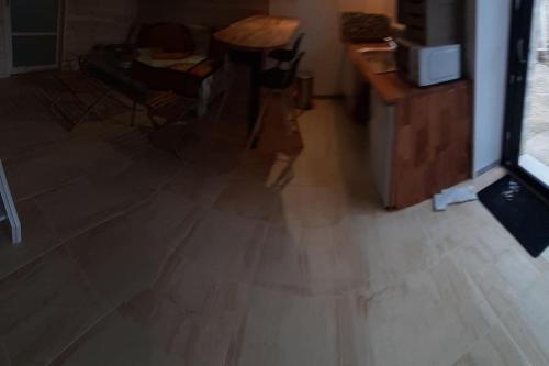 Habitación con suelo de madera, mesa y sillas. en Agréable gite au calme, en Marigny