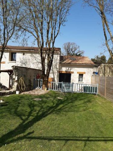 una casa blanca con una valla en un patio en Agréable gite au calme, en Marigny