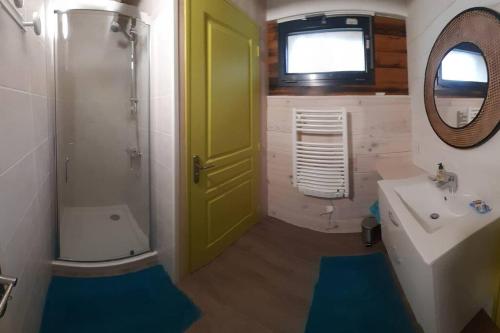 La salle de bains est pourvue d'une porte verte et d'un lavabo. dans l'établissement Agréable gite au calme, à Marigny