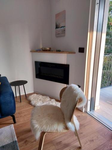 a living room with a white chair and a fireplace at GO Jahorina by Olympic Gardens in Jahorina