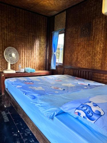 a large bed with blue sheets in a bedroom at Blue stone in Pai