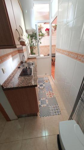 małą kuchnię ze zlewem i podłogą wyłożoną kafelkami w obiekcie Rico Apartaments Ricosol w mieście Torrox Costa