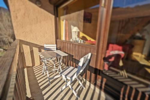 een tafel en stoelen op het balkon van een huis bij L'Hermine - duplex à 5mn des pistes, plein sud in Saint-Chaffrey