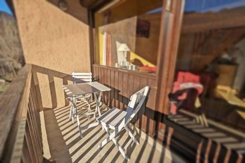 une table et des chaises sur le balcon d'une maison dans l'établissement L'Hermine - Duplex à 5mn des pistes avec garage, à Saint-Chaffrey